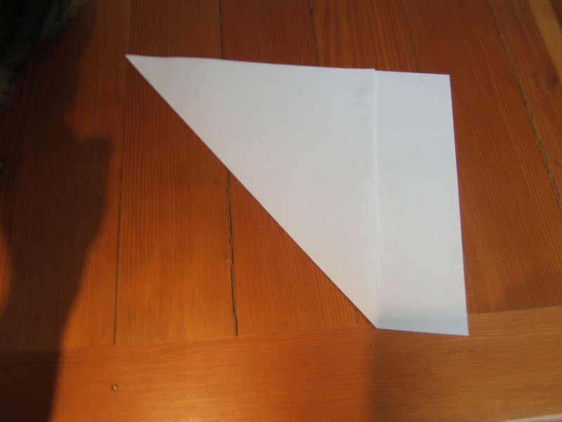 Gập chéo tờ giấy cắt phần thừa để được tờ giấy hình vuông làm cây thông Noel