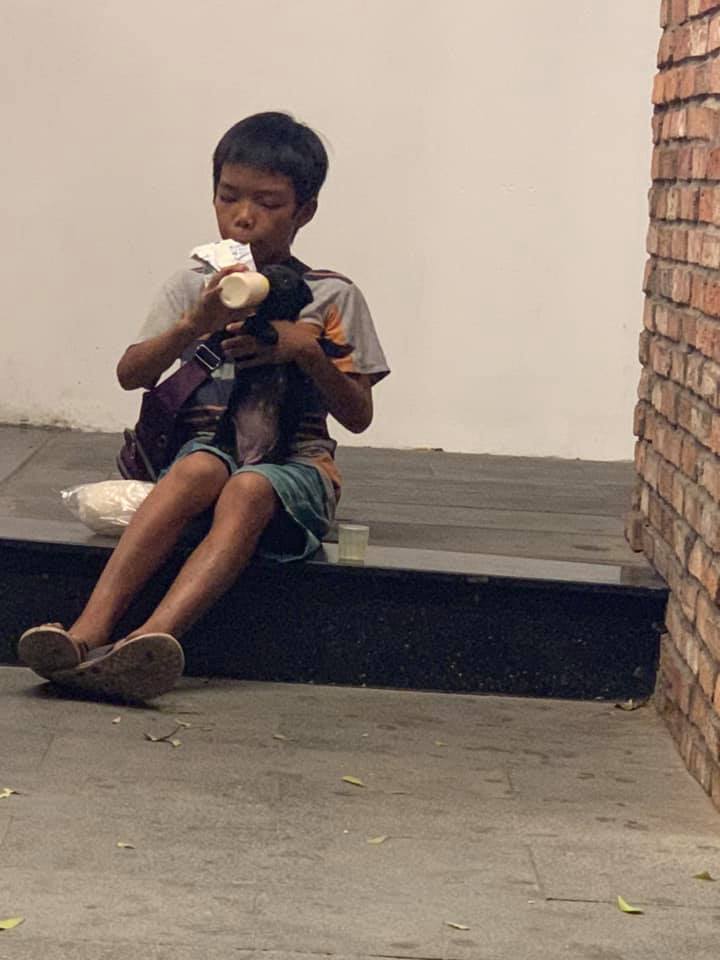 Hình ảnh khiến hàng triệu trái tim rung động: Cậu bé bán vé số chia đôi bịch sữa cho chú chó con bên đường - Ảnh 3