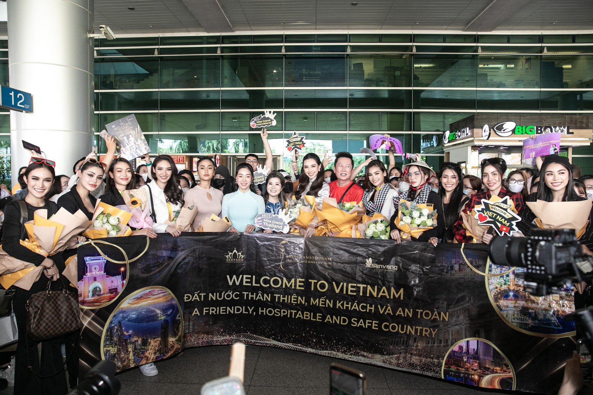 Thùy Tiên diện áo dài trắng ra sân bay đón Mr. Nawat và top 10 Miss Grand Thái Lan 2022 đến Việt Nam  - Ảnh 2