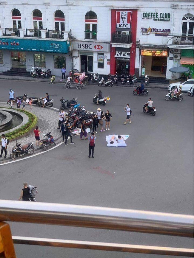 Chuyện lạ nhất phố Hà Nội hôm nay: Đôi bạn trẻ bày gối, trải chăn nằm đọc sách ngay giữa quảng trường bất chấp xe cộ qua lại khiến dân mạng cực kỳ tranh cãi - Ảnh 1