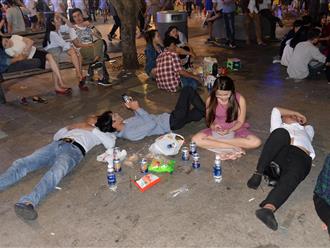 Hình ảnh "nhìn thôi đã mệt": Thanh niên say bét nhè nằm lăn ra giữa phố đi bộ, trẻ con đi theo bố mẹ vạ vật chờ giao thừa