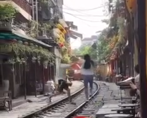 Hốt hoảng nữ du khách lao ra đường ray để 'sống ảo' khi tàu hỏa đến ở Hà Nội - Ảnh 1